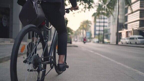 近距离的脚商人是骑自行车在城市的街道上为他的早晨通勤工作生态交通