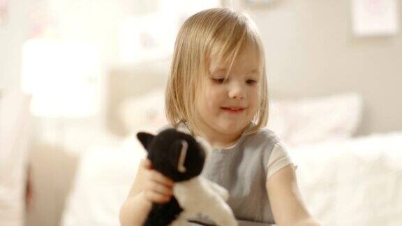 快乐的小女孩在她的房间里玩毛绒玩具缓慢的运动