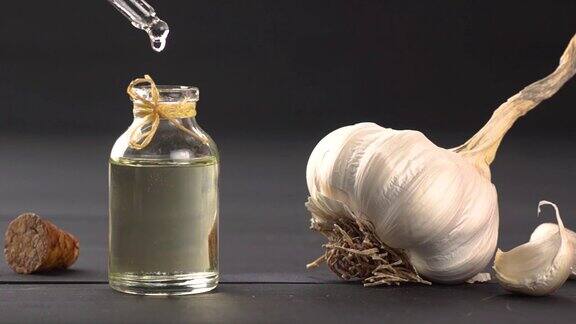 熟蒜和生蒜油放在黑木桌上的瓶子里油滴着