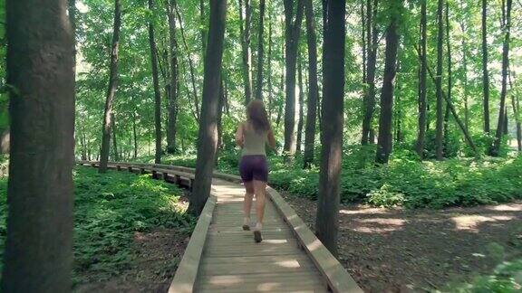 户外运动一个穿着短裤、腿修长的女孩在公园里跑步