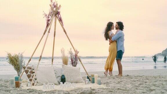 一对幸福的年轻情侣在求婚后在海滩上拥抱一对相爱的男女亲吻并庆祝他们的订婚