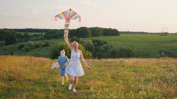 一个女人和一个拿着风筝跑的女孩快乐的妈妈和女儿