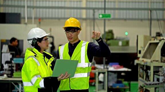 4K男、女工程师在重工业制造工厂使用笔记本电脑工作