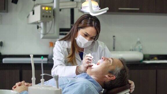 牙医正在给她的病人洗牙