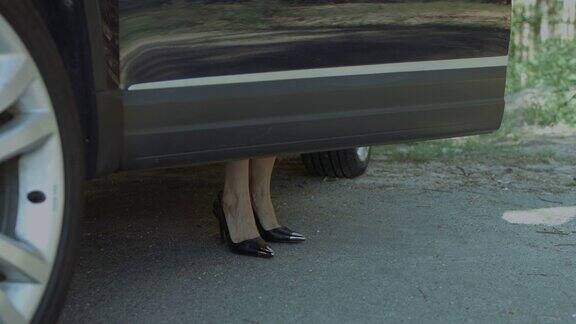 优雅的女性腿在高跟鞋进入汽车