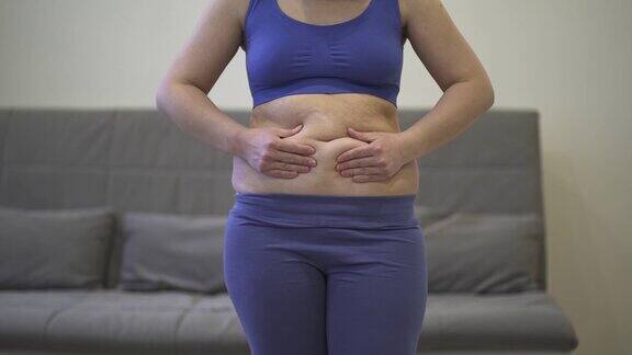 腹部按摩用抗脂肪霜腹部整形和松弛的皮肤对肥胖的腹部女性做自我按摩