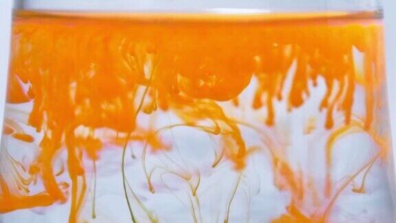 橘色油漆滴墨滴在水里流动流体黄色染料飞溅飞溅
