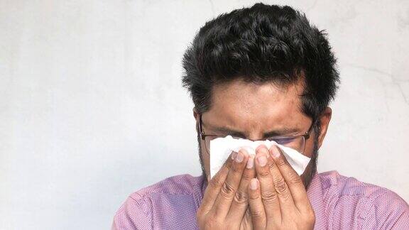 生病的年轻人得了流感过敏用手帕打喷嚏擤鼻涕