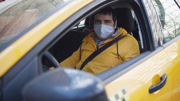 戴着防护面具和橡胶手套开出租车的男人