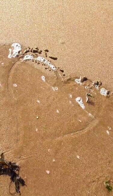 被海水卷走的沙上画的心形破碎的心