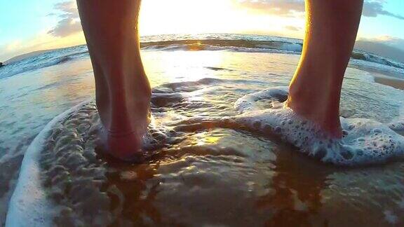 海浪冲刷着海滩上年轻女孩的脚