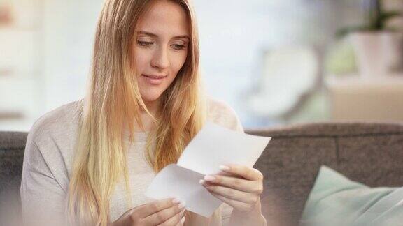 年轻迷人的白人女子收到信和微笑的喜悦