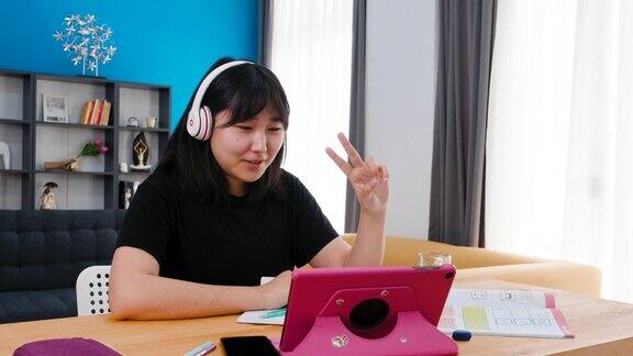十几岁的女孩戴着耳机在家学习
