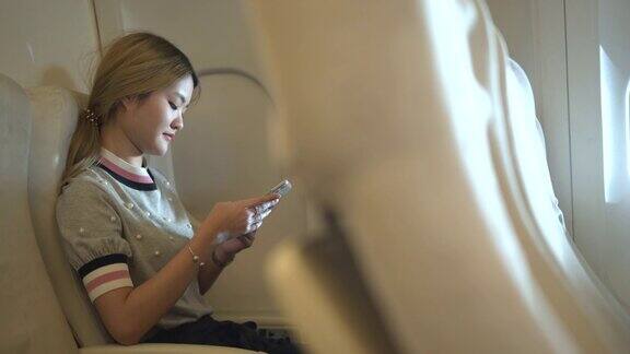 年轻女子在飞机上使用手机