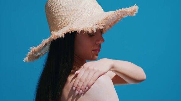 年轻的亚洲女性在肩膀上涂防晒霜享受阳光
