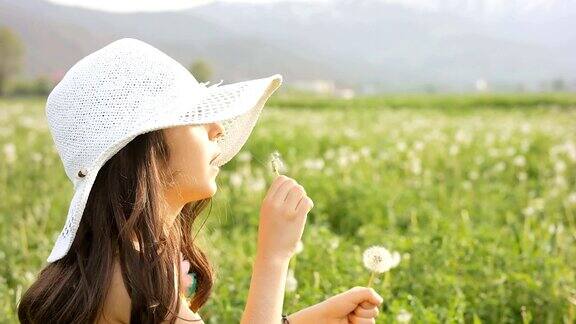 慢动作女孩用蒲公英种子旋转