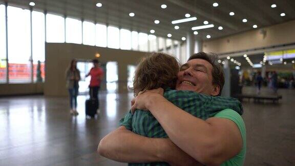兴奋的小男孩去机场接他的父亲跑着去拥抱他非常开心