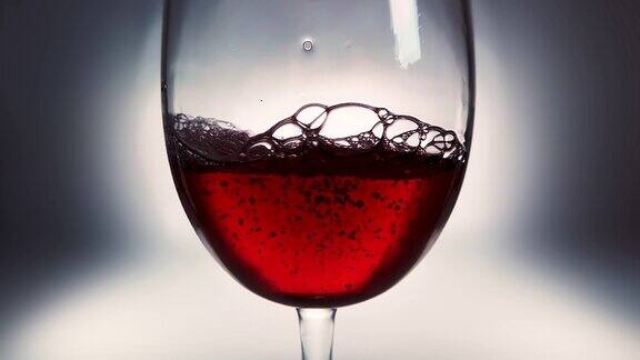 红酒倒入玻璃杯的创意宏慢动作视频玻璃杯与红葡萄酒的特写老式的复古风格