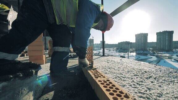 男性建筑工人把砖排成一排建筑工地、建筑行业、建筑工人概念