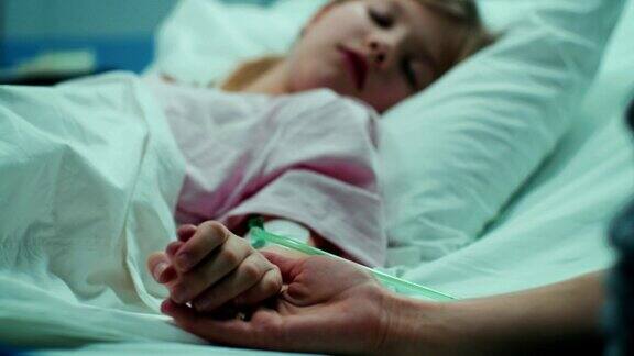 小女孩躺在病床上睡觉妈妈握着她的手安慰她情感家庭的时刻