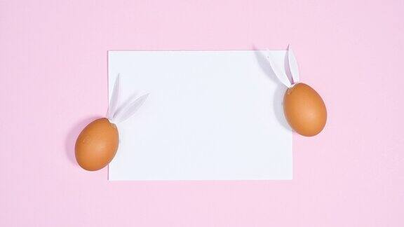 纸卡片复制空间与创意复活节兔子蛋在柔和的粉红色背景停止运动