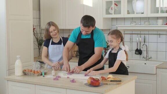 小女孩和父母在家里做饼干