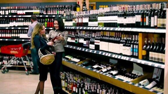 两个漂亮的朋友在超市挑选葡萄酒