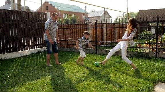 父母喜欢和活泼的男孩在草坪上踢足球