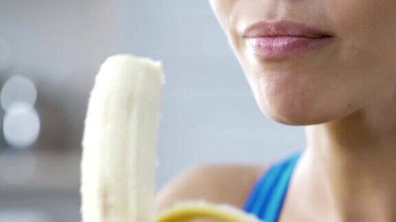 年轻的女士微笑着吃香蕉快速健康的零食休息卡路里
