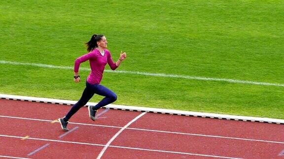 年轻的女运动员在跑道上训练慢动作录像