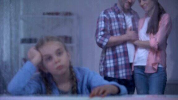 悲伤的孤儿在雨窗旁养父母从孤儿院带走了女孩
