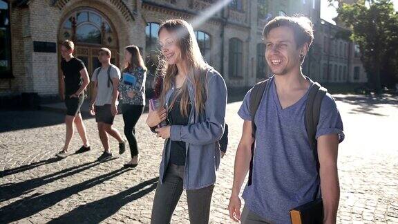 两个快乐的学生走在大学校园里