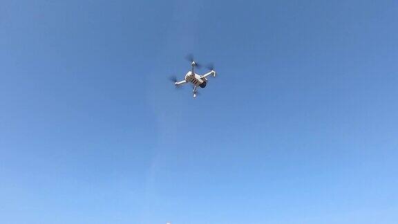 一架白色四轴飞行器在湛蓝的天空背景下
