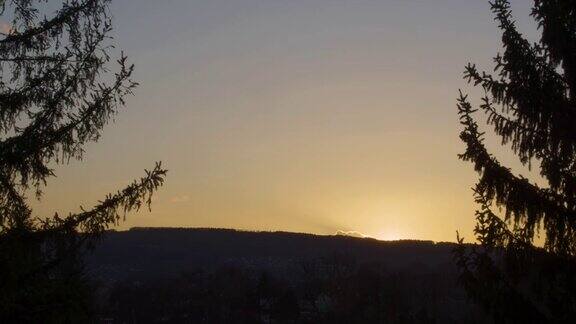 间隔拍摄日落山上的夕阳一棵树的剪影