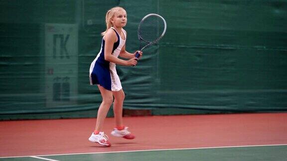 年轻女孩在室内场地训练网球她在教如何发球