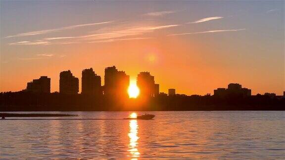 城市的日落前景是平静的水摩托艇在湖上行驶