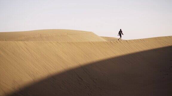 行走在沙漠沙丘上的人