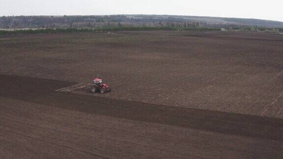 无人机拍摄的拖拉机犁地准备收割庄稼灰尘拖拉机在尘土飞扬的干旱土壤中犁地耕耘者犁地在田间工作在田间播种农作物