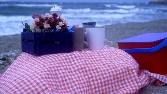 沙滩上的毯子上放着野餐篮子