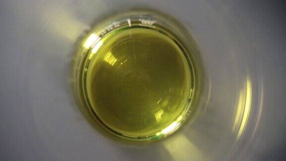 透明黄色油在玻璃化学试管的特写