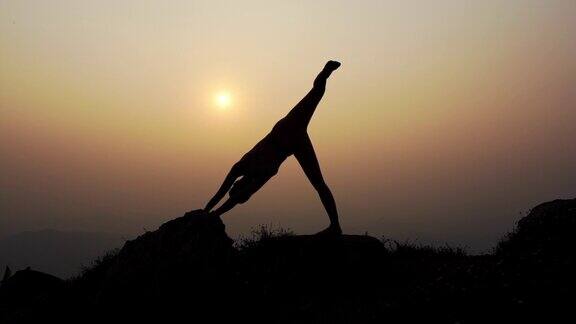 剪影练习瑜伽姿势平衡身体至关重要的禅冥想在自然天空山在日落的背景