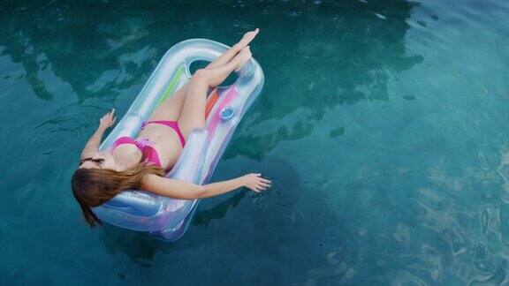 一个白人女人在阳光明媚的日子里享受游泳池