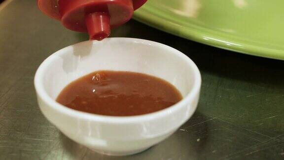 红番茄酱挤进酱碗