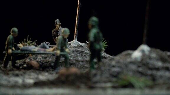 微型玩具士兵在战场上抬着一副担架上面有一名受伤的士兵