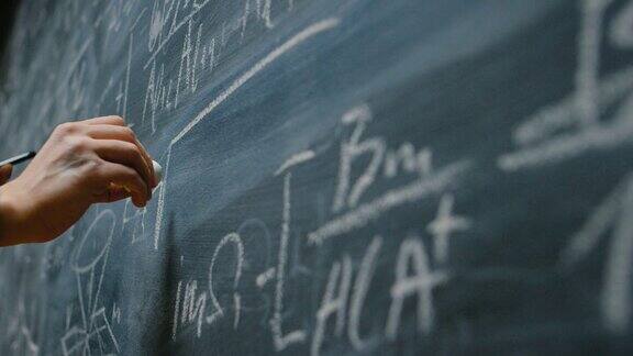 手持粉笔在黑板上写下复杂复杂的数学公式