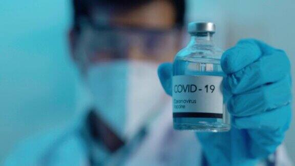 在实验室里32岁的年轻男性亚洲科学家手拿疫苗展示科学实验室