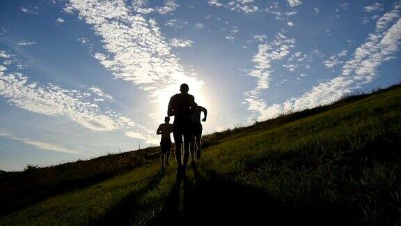 年轻人跑过青山头顶蓝天日落时分男运动员在大自然中慢跑运动跑步者慢跑的户外日出与flare越野训练Slowmotion