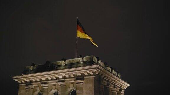德国国旗在夜间在联邦议会大厦上飘扬慢动作