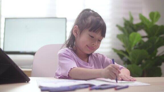 亚洲女儿在家里用数字平板电脑学习在线课程