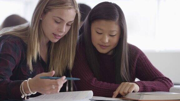 两个女孩在教室里一起学习